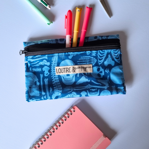 Pochette reverso - Traumato Pochette reverso plastifiée pour stylos et téléphone avec des os